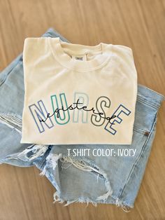 a t - shirt with the word nurse on it sitting next to some ripped jeans