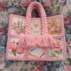 a pink purse with tassels and flowers on it