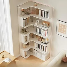 a white book shelf in the corner of a living room filled with books and knick - knacks