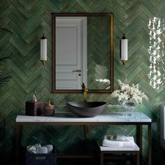 a bathroom with green wallpaper and a large mirror over the sink in front of it