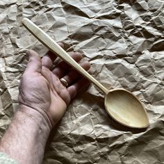 a person holding a wooden spoon in their hand