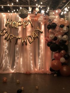 balloons and streamers decorate the backdrop for a happy birthday party in an industrial setting