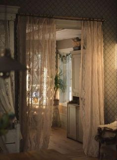 an open door leading to a bedroom with curtains