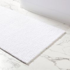 a white bath mat sitting on top of a bathroom counter