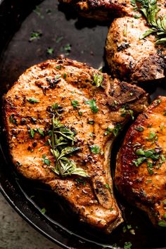 grilled pork chops with herbs and seasoning in a cast iron skillet