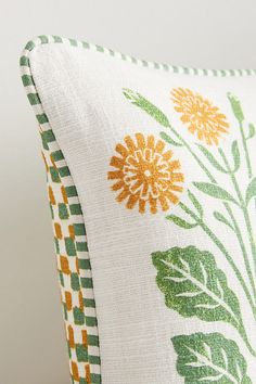 a white pillow with yellow and green flowers on it