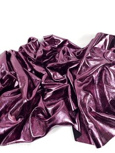 a pile of shiny purple material on top of a white surface