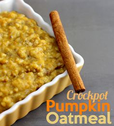 a cup filled with pumpkin oatmeal next to two cinnamon sticks