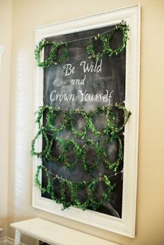 a chalkboard with green vines on it and a sign that says be wild and crown yourself