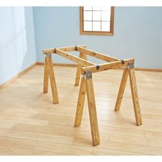 a wooden frame sitting on top of a hard wood floor in front of a window