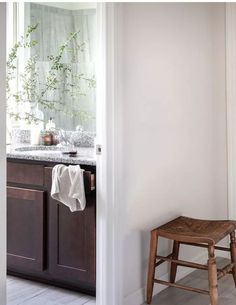 a wooden stool sitting next to a bathroom sink