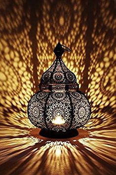 an intricately designed lamp is lit by the light coming from it's shadow