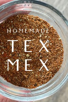 a person holding a glass jar filled with some kind of food that says homemade tex mex