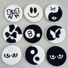 six black and white buttons with smiley faces on them, all decorated in different designs