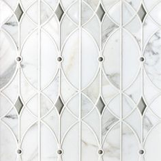 a white marble tile wall with an intricate design on it's sides and the top part of the tiles