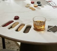 a glass of alcohol sitting on top of a table next to playing cards and chips