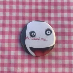 a button with the words no want me on it sitting on a pink and white checkered table cloth