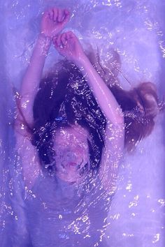 a woman in the water with her arms above her head