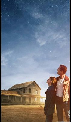 two people standing in front of a house under the stars