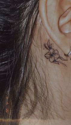 a close up of a person's ear with flowers on the back of their ear