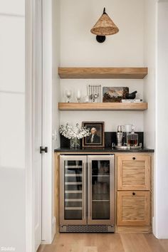 a kitchen with open shelving and wooden shelves on the wall next to a wine cooler