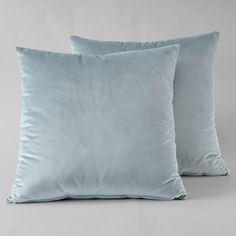 two light blue pillows sitting on top of each other