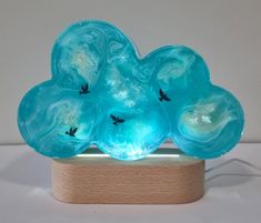 a blue glass sculpture sitting on top of a wooden stand