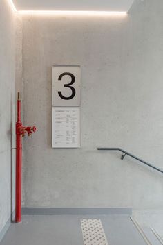 a red fire hydrant sitting next to a white wall