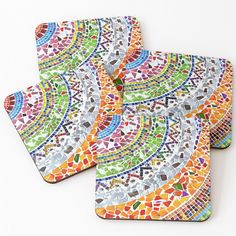 three coasters with colorful designs on them