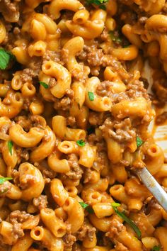 a plate full of macaroni and cheese with a spoon