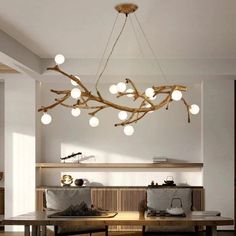 a dining room table and chairs with lights hanging from the ceiling