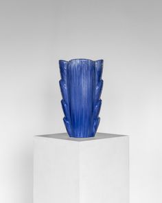 a blue vase sitting on top of a white pedestal