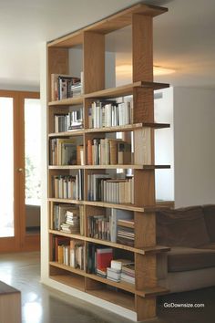 a bookshelf filled with lots of books in a living room