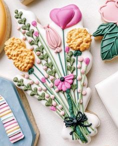 cookies decorated with flowers and leaves are on a table next to other cookie cutters