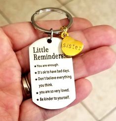 a hand holding a keychain with a poem on it that says, little reminders you are enough