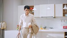 a man holding a bag in his hand while walking through a kitchen