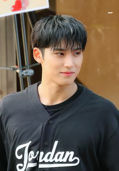 a young man with black hair wearing a baseball uniform