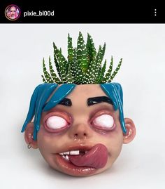 a fake head with plants growing out of it's eyes and tongue, on a white background