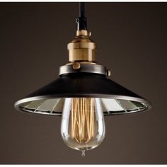 an old fashioned light bulb hanging from a ceiling fixture in a dark, industrial - style room