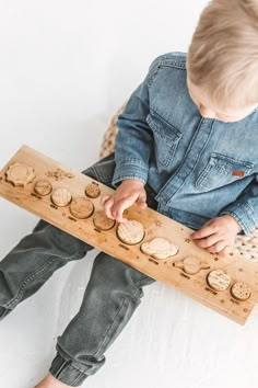 a toddler is playing with a wooden toy