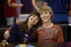 two young people sitting at a table smiling