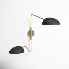 two black and gold wall lamps against a white wall with one light on the side