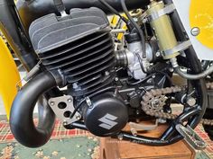 an old motorcycle engine sitting on top of a wooden stand