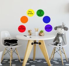 two chairs and a table with colorful circles on the wall behind them that say fun