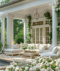 an outdoor living area with white furniture and flowers