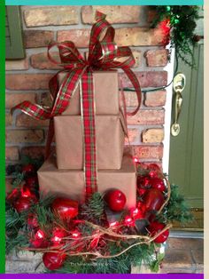 a stack of wrapped presents sitting on top of a christmas wreath