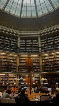 a library filled with lots of books and people sitting at tables in front of them