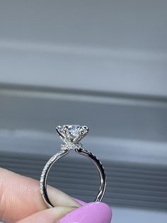 a person holding a diamond ring in their hand