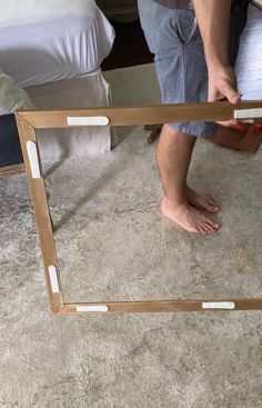 a man standing in front of a mirror with his feet on the floor and one hand reaching for it