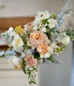 a vase filled with lots of different colored flowers